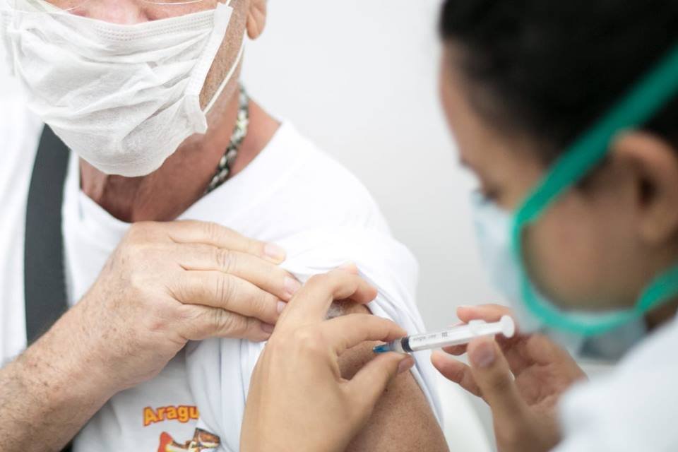 Aplicação de vacina no braço de uma pessoa