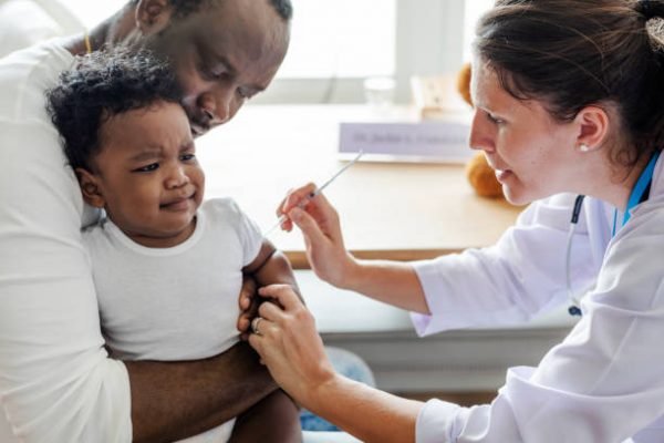 Bebê negro tomando vacina
