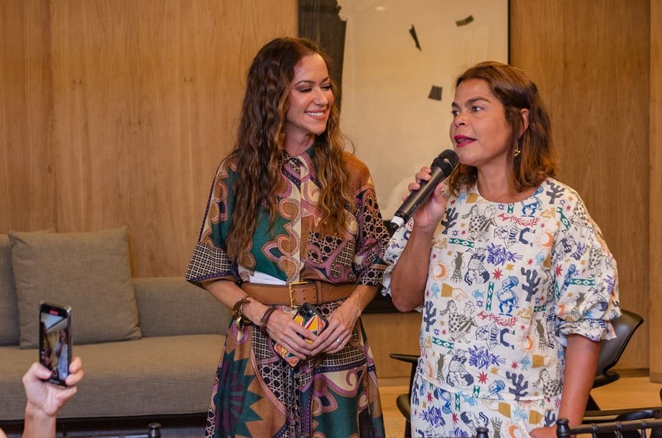 Duas mulheres juntas, uma com microfone