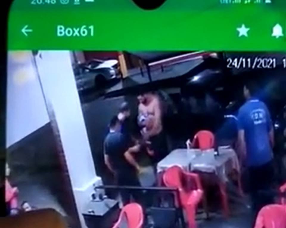Homem de camisa pega alguma coisa no chão