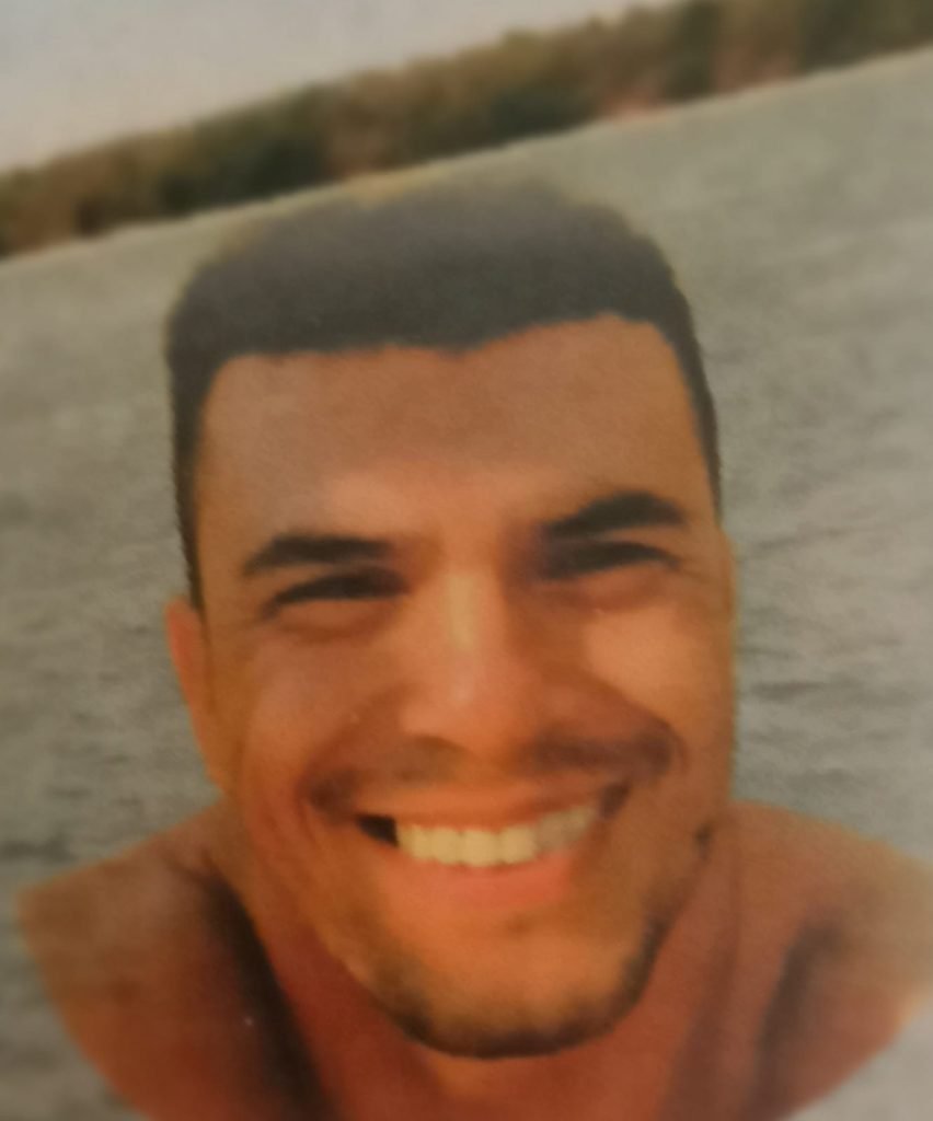Marcos Antônio, foto sorrindo em frente ao lago