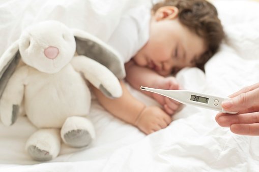 criança dormindo e mão mostrando termômetro