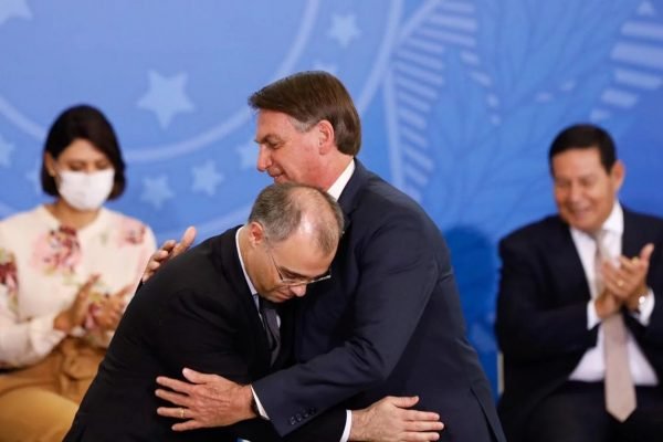 Fotografia colorida com dois homens se abraçando. Do lado esquerdo, o ministro do STF André Mendonça. À direita, presidente Jair Bolsonaro