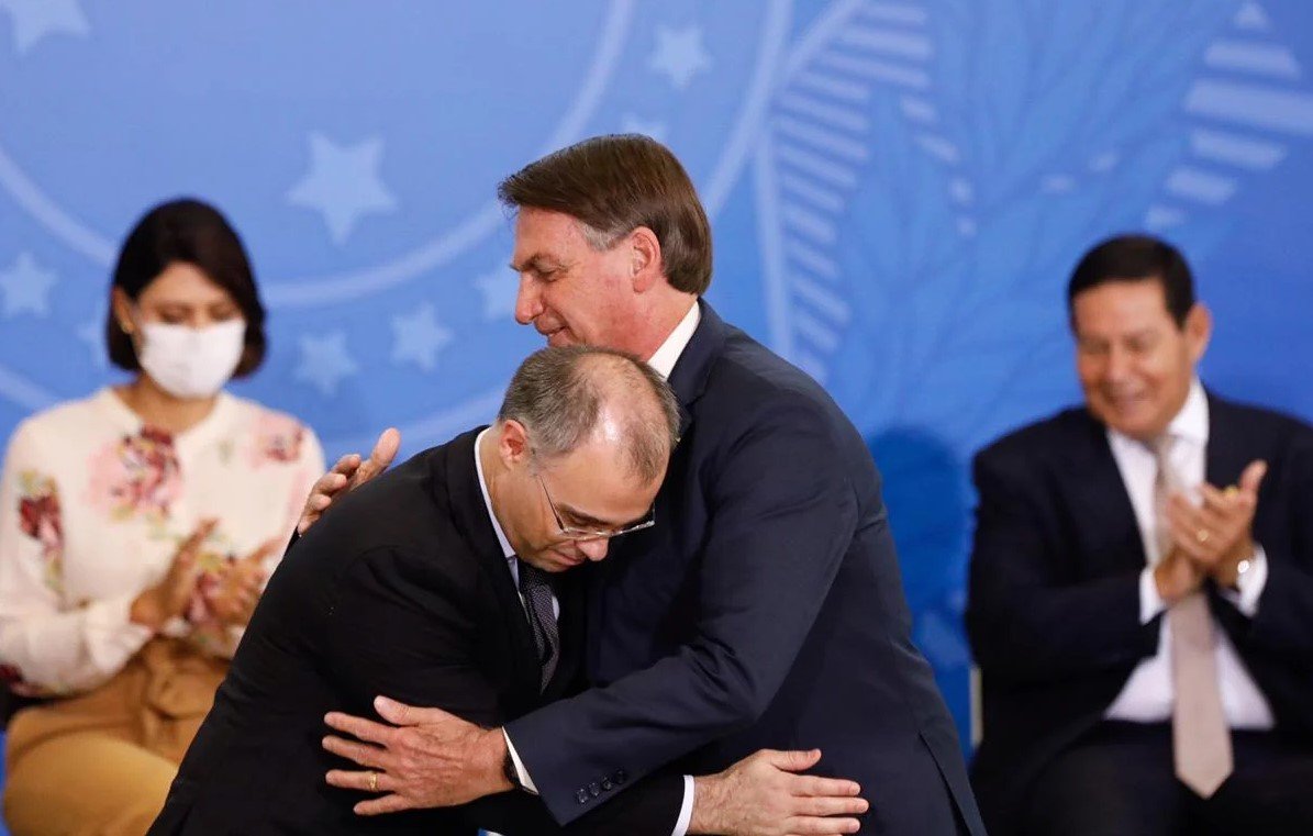 Fotografia colorida com dois homens se abraçando. Do lado esquerdo, o ministro do STF André Mendonça. À direita, presidente Jair Bolsonaro