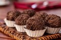 Na foto, seis brigadeiros enrolados em ganulado e colocados em forminhas brancas