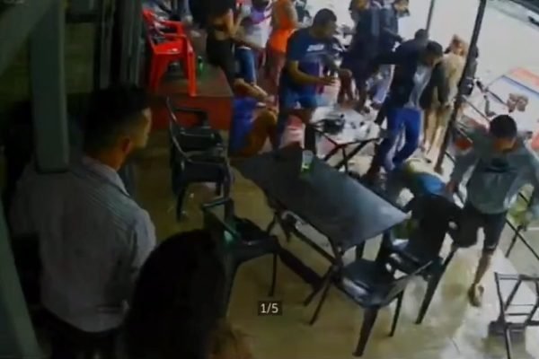Pessoas brigando perto de mesas e cadeiras