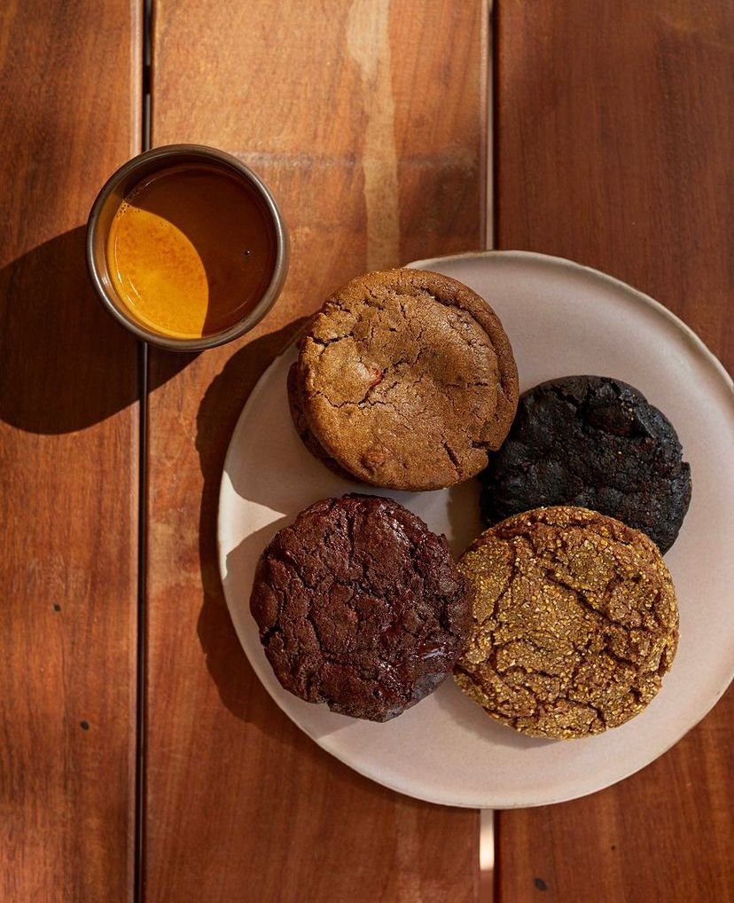 Na foto, quatro biscoitos e uma xícara de café