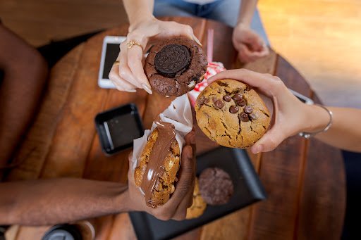 Na foto, quatro pessoas segurando vários cookies