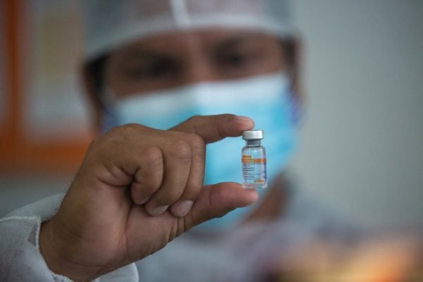 enfermeiro segura frasco de vacina coronavírus