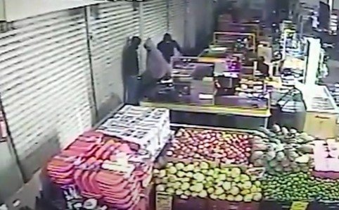 Três homens de capuz em uma feira roubando o estabelecimento
