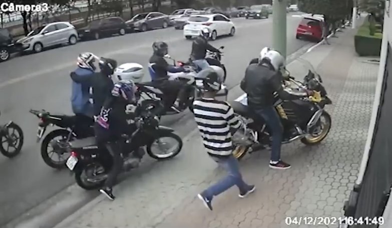 Em menos de um minuto, os ladrões chegam com motos, abordam as vítimas fazendo gestos que indicam que poderiam estar armados e fogem com as motos roubas