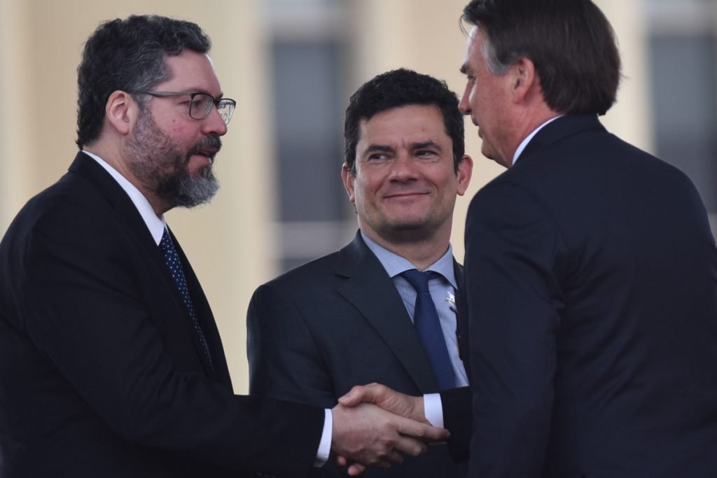 os ministros de Relaçoes Exteriores, Ernesto Araujo, e da Justiça, Sergio Moro, ao lado do presidente Bolsonaro.