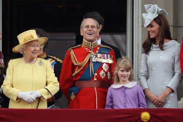 Na fotografia colorida, Louise (de roxo) aparece perto dos avós, Elizabeth II e Philip, e próxima à Kate
