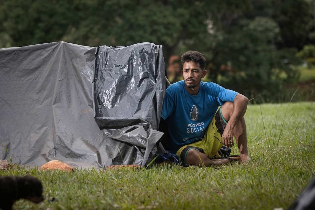 homem sentado na entrada de uma barraca