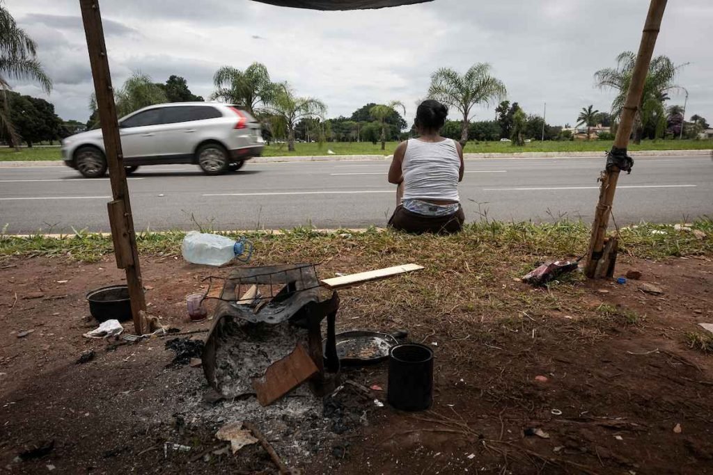 mulher sentada no meio fio de costas
