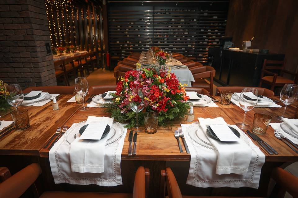 Mesa com pratos, copos e arranjos de plantas