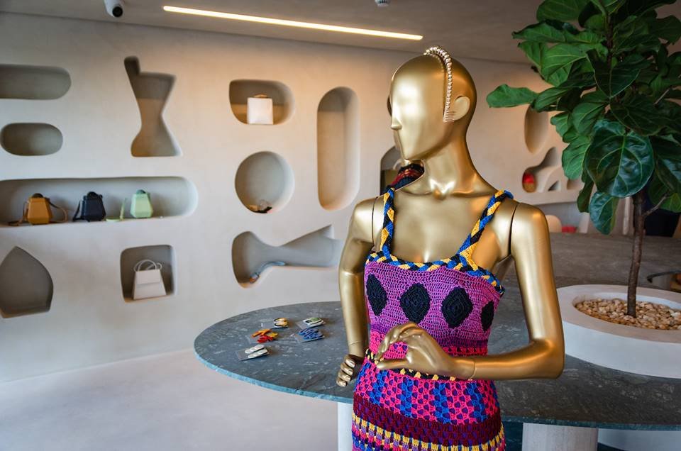 Manequim dourado com roupa na cor roxa