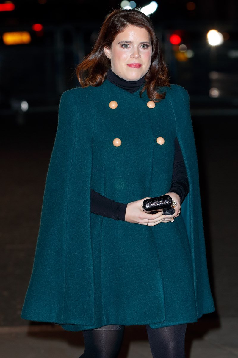 Mulher com vestido verde segurando uma bolsa