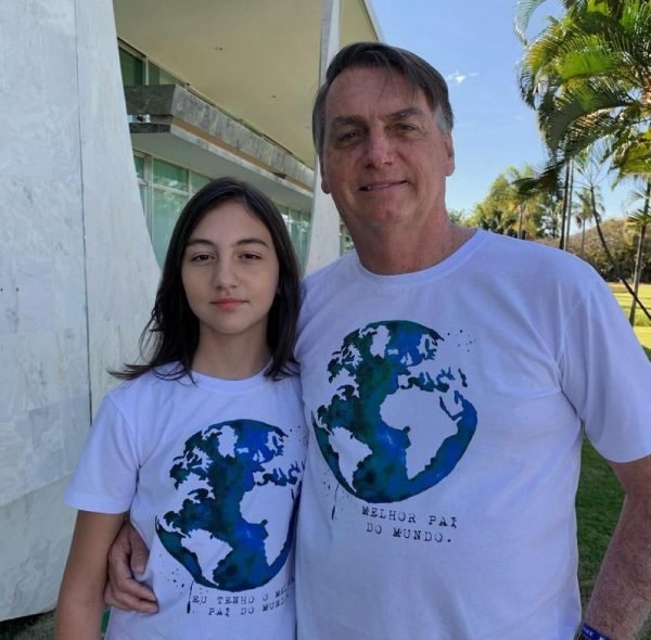 In the colorful photo, Bolsonaro poses with his daughter Laura in her arms