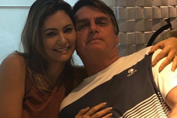 In the colorful photograph, Michelle and Bolsonaro pose for a photo, smiling and hugging each other.