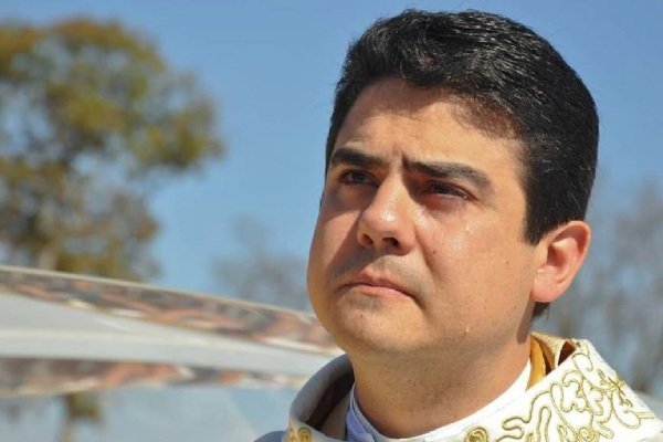 Na fotografia colorida, padre Robson aparece à direita da imagem com as vestes sacerdotais