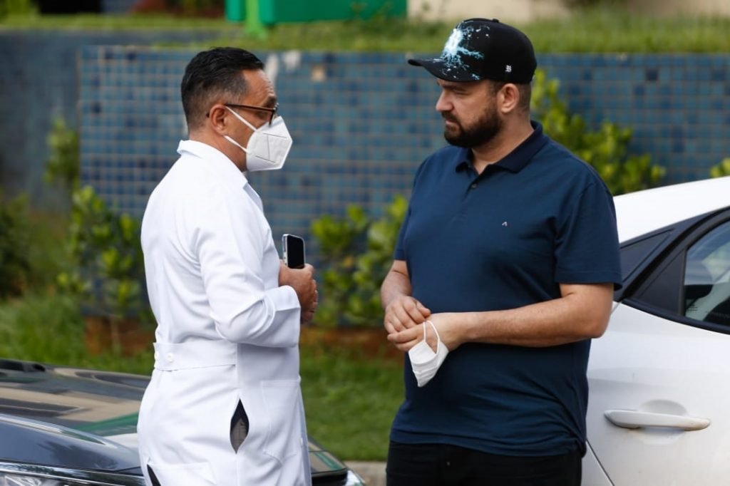 Médico Wandervan Azevedo conversa com produtor do cantor Maurílio, André Abrahão, na porta de hospital em Goiânia