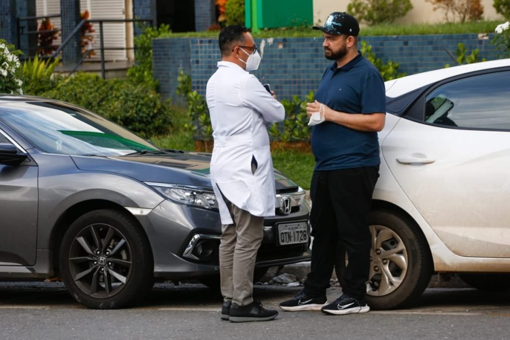 Médico Wandervan Azevedo conversa com produtor do cantor Maurílio, André Abrahão, na porta de hospital em Goiânia