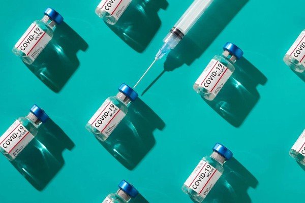 fotografia colorida.  Frasco de vacina Covid-19 com uma seringa