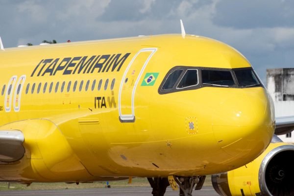 Avião amarelo, da Itapemirim, parado em pista de aeroporto
