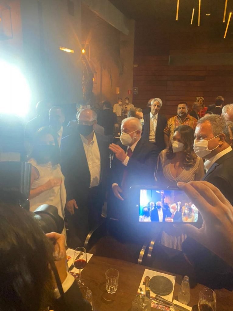 Em jantar em São Paulo, Alckmin e Lula se reúnem com aliados e entusiastas de uma possível aliança. Eles tiram foto no restaurante cheio, acompanhados por suas esposas. Ambos usam terno e conversam - Metrópoles