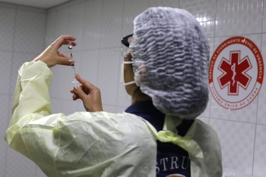 Imagem colorida de enfermeira com dose de vacina