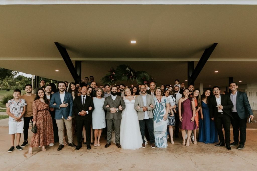 Pastel com caldo de cana: casal comemora união em pastelaria no DF - Veja fotos 4 Grupo de convidados reunidos para foto, noivo e noiva ao centro