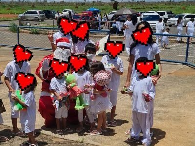 Crianças juntas com uniforme branco e corações no lugar