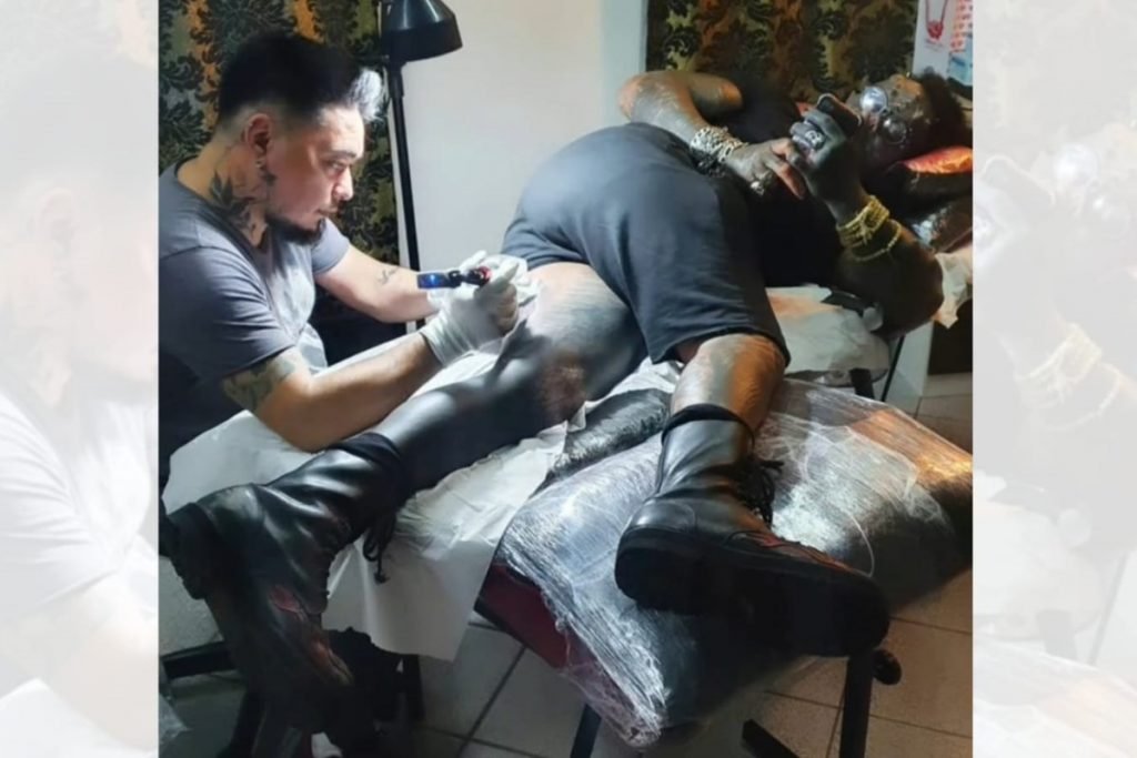 Perna de Diabão sendo tatuada com imagem de Black Alien