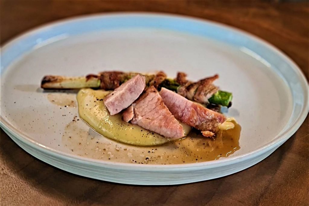 Na foto temos um prato com picanha cortada em tiras e aligot