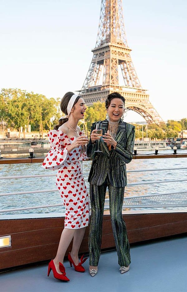 Atrizes da série Emily in Paris em frente à Torre Eiffel