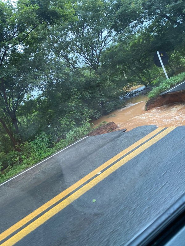 Estrada com cratera preenchida por água lamacenta