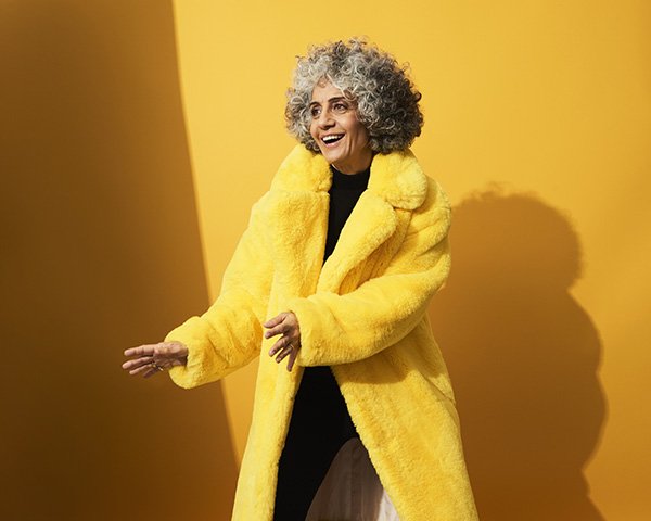 Mulher idosa com casaco de pele amarelo