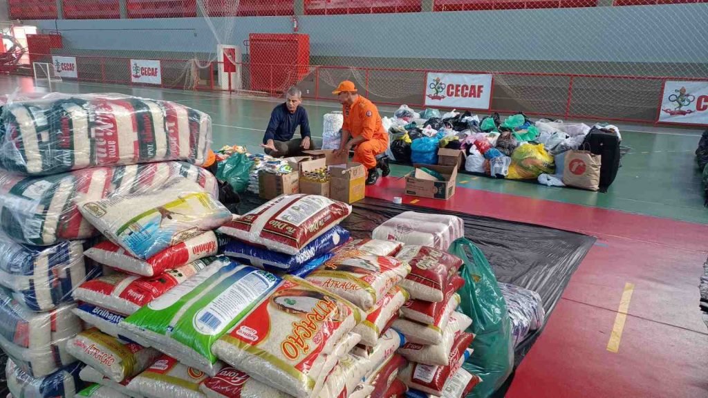 doações saco de arroz e homens agachados