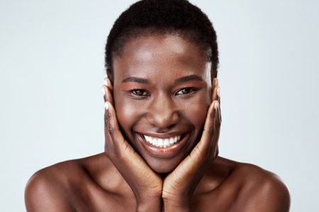 mulher negra sorrindo com pele brilhante