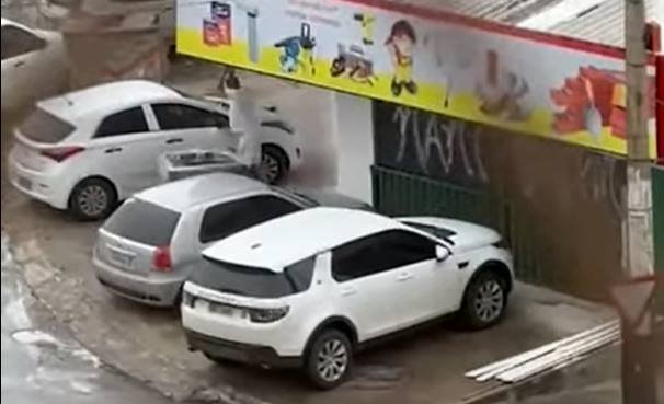 Carros estacionados e homem com pedra vestido de roupas brancas
