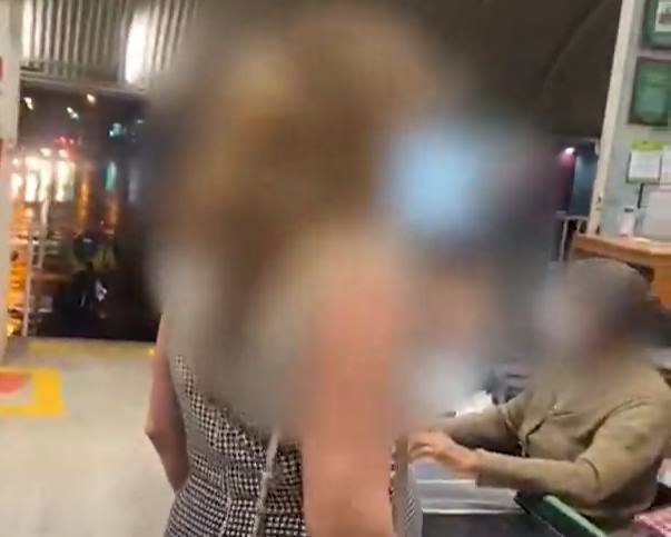Mulher ao lado de caixa de supermercado