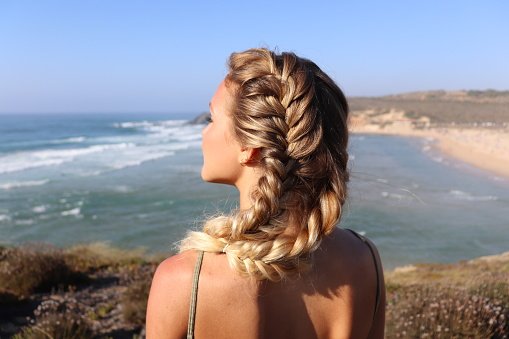 mulher com trança no cabelo na praia
