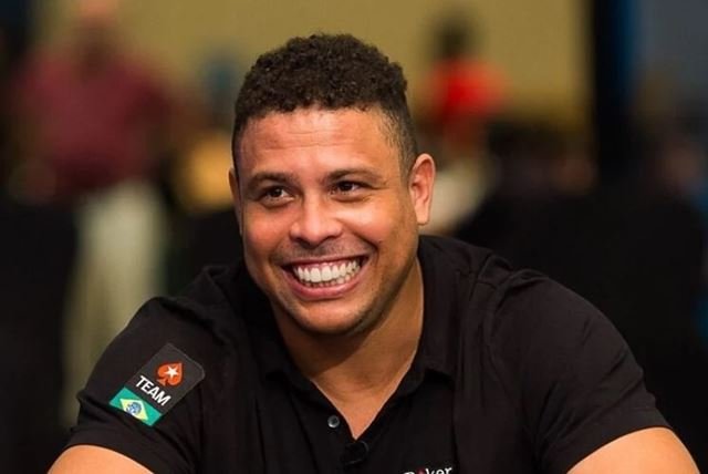 Fotografia colorida de Ronaldo vestindo camisa preta e sorrindo