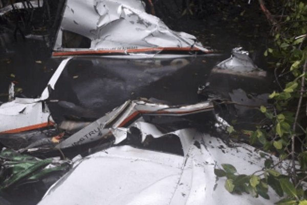 Fotografia colorida de destroços do avião na água