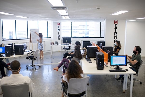 Foto colorida mostra sala de aula do Mentor, programa de estágio em jornalismo do Metrópoles