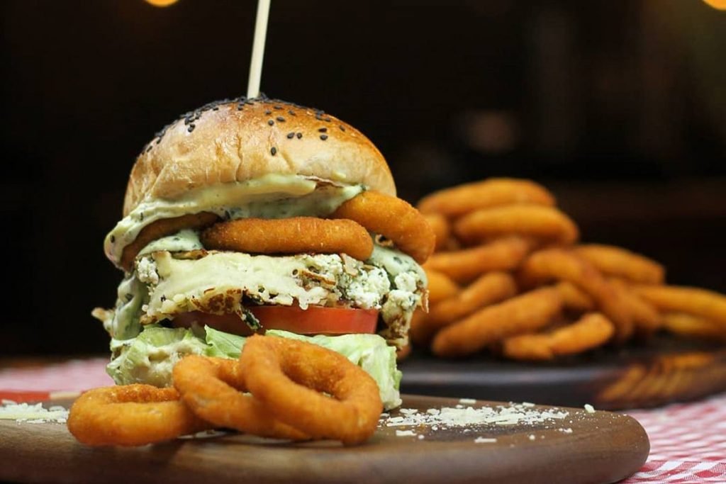 Na foto temos um hamburguer e aneis de cebola