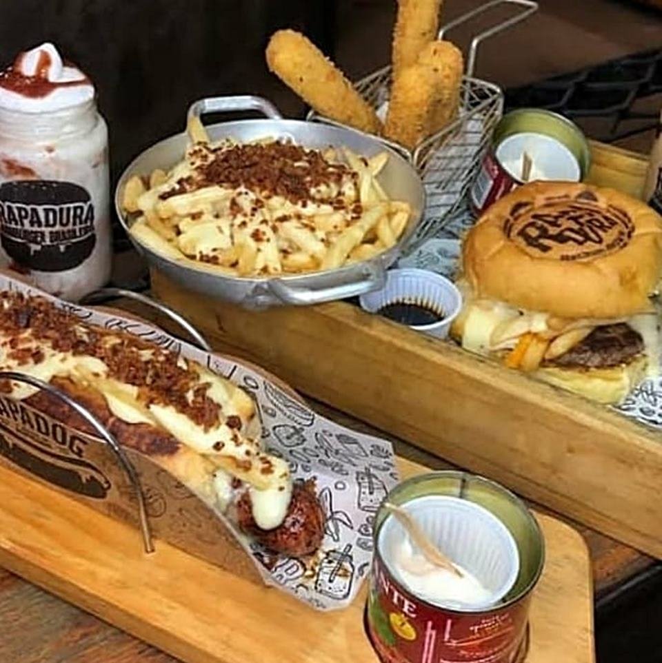 Na foto temos batatas fritas, hamburguer, cachorro quente e milkshake