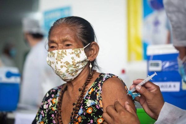 Color photo of an elderly woman receiving a covid vaccine