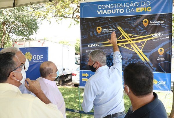 Homem mostra cartaz para ouro homem